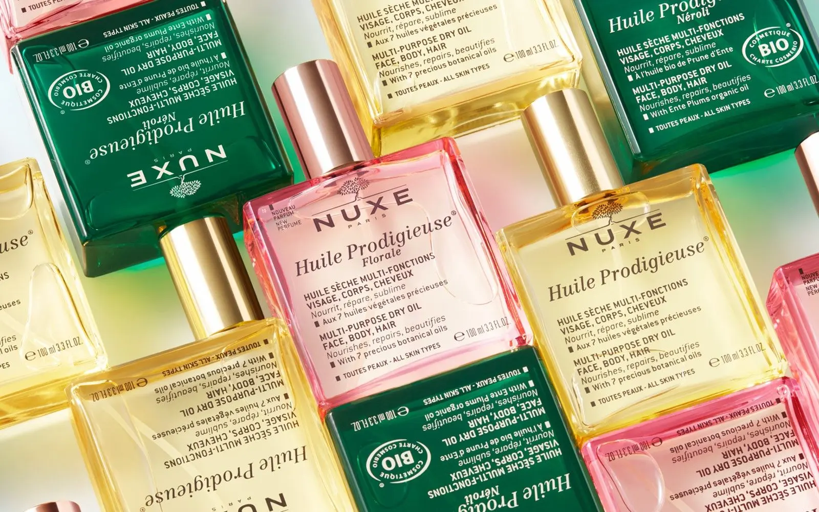 Bilde av Nuxe olje flasker, grønne, gule og rosa.