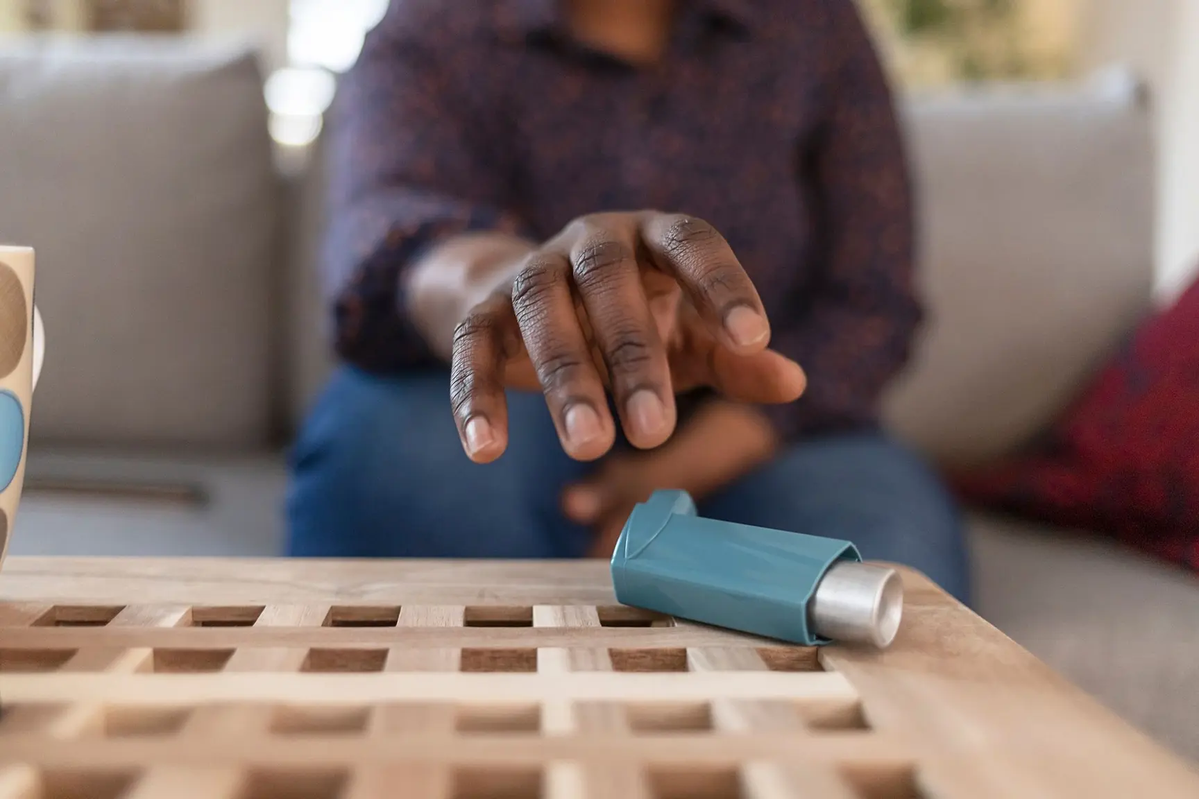 Kvinne strekker hånden ut etter en inhalator
