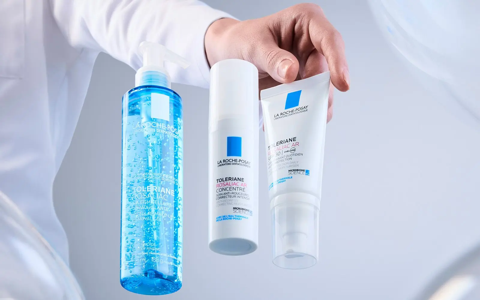 En person med laboratoriefrakk viser frem 3 produkter i serien LRP Toleriane Rosaliac