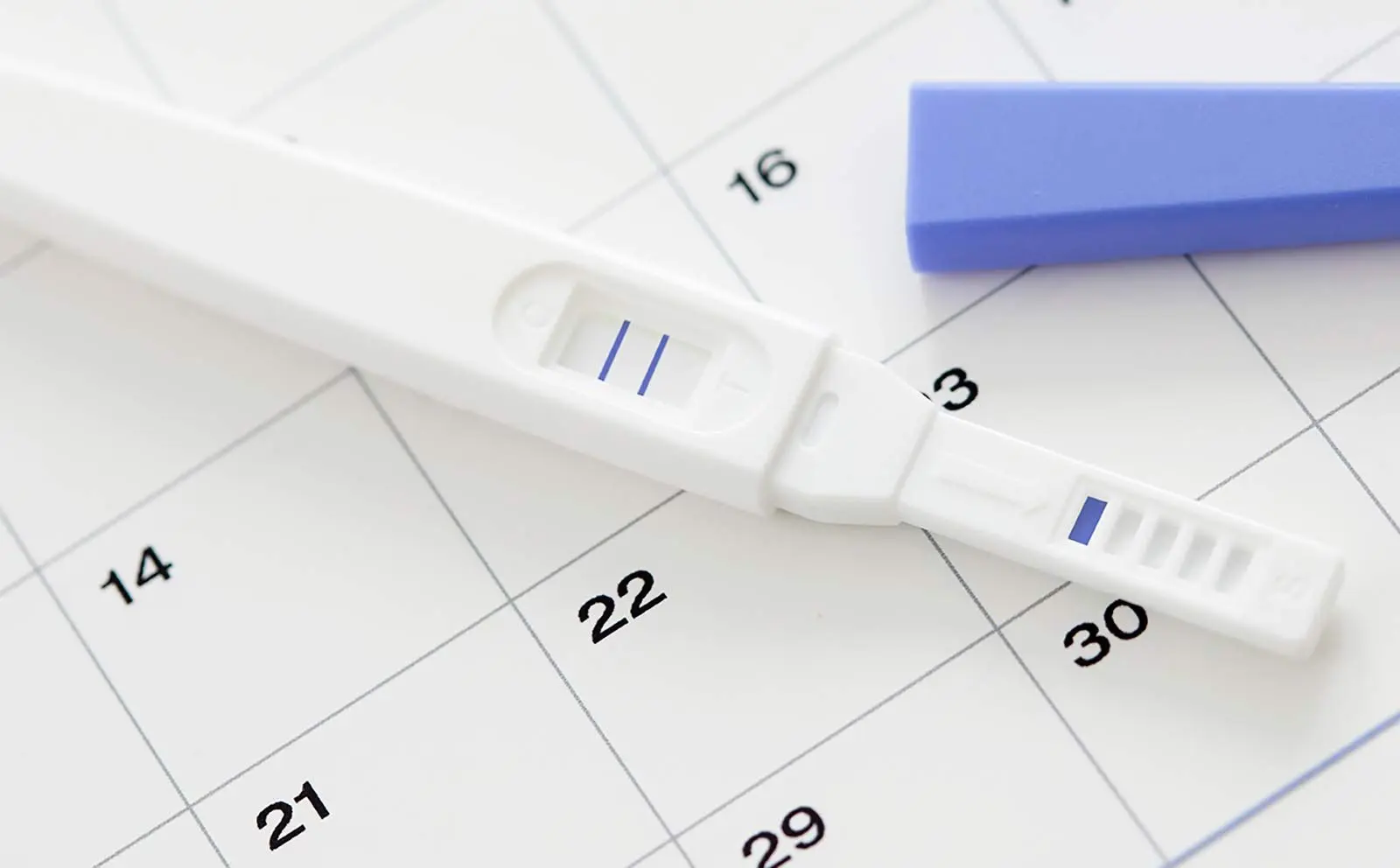 En positiv test ligger over en kalender