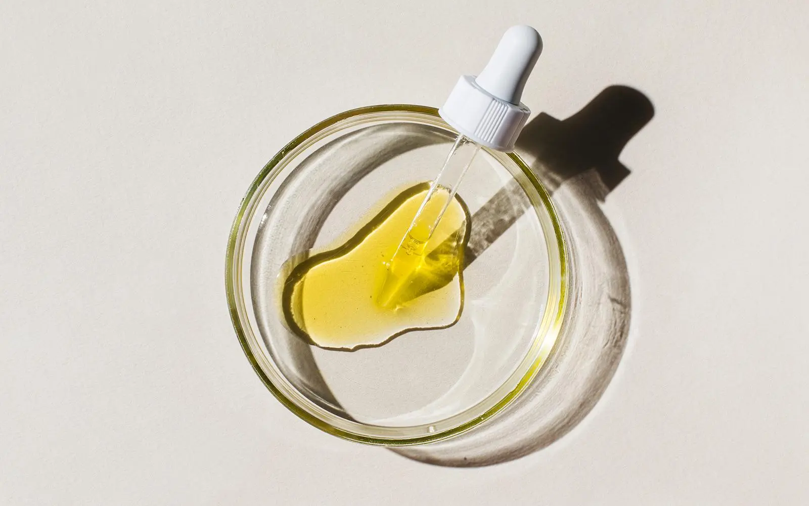 Petriskål med pipette fylt med olje