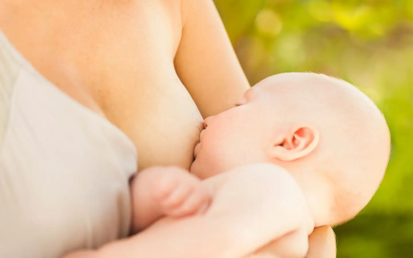 Bilde av baby som ammer av mors bryst.