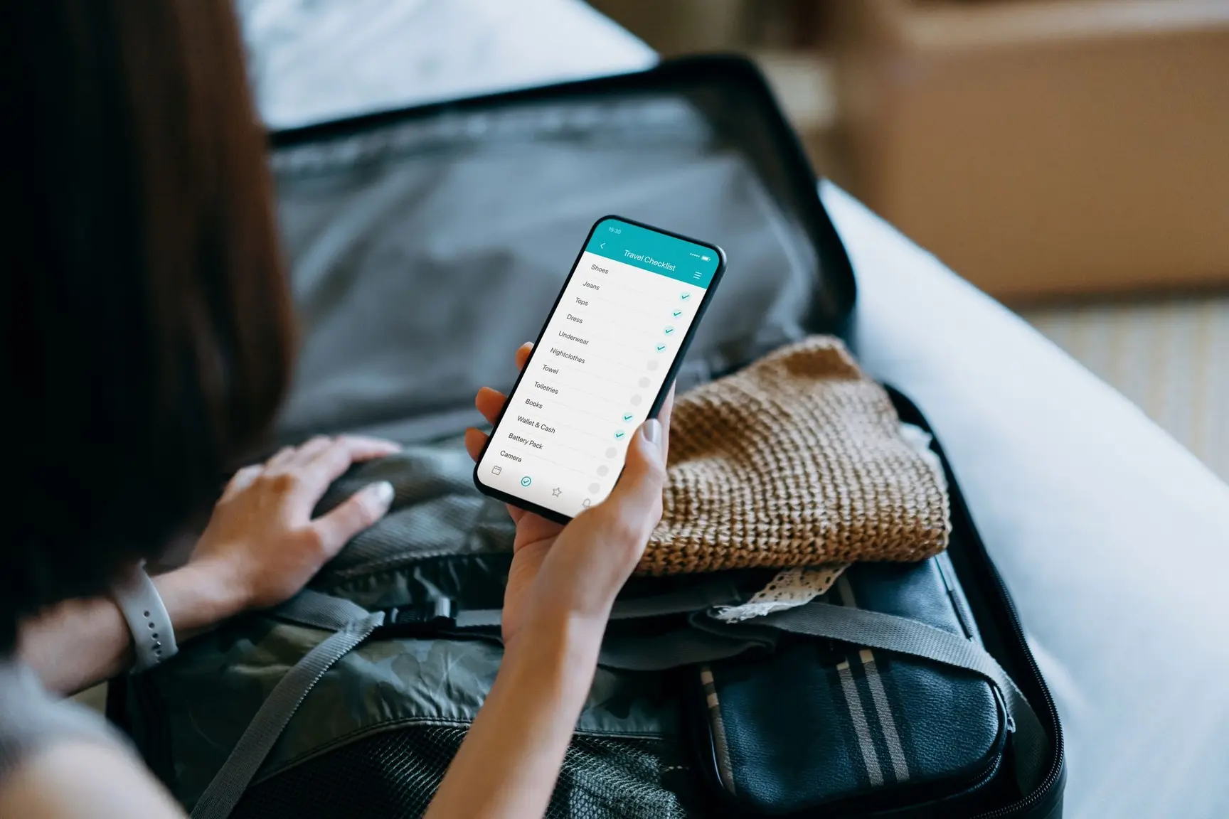 Kvinne ser på en sjekkliste for reise på mobilen