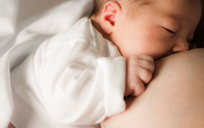 Bilde av en baby som blir ammet.