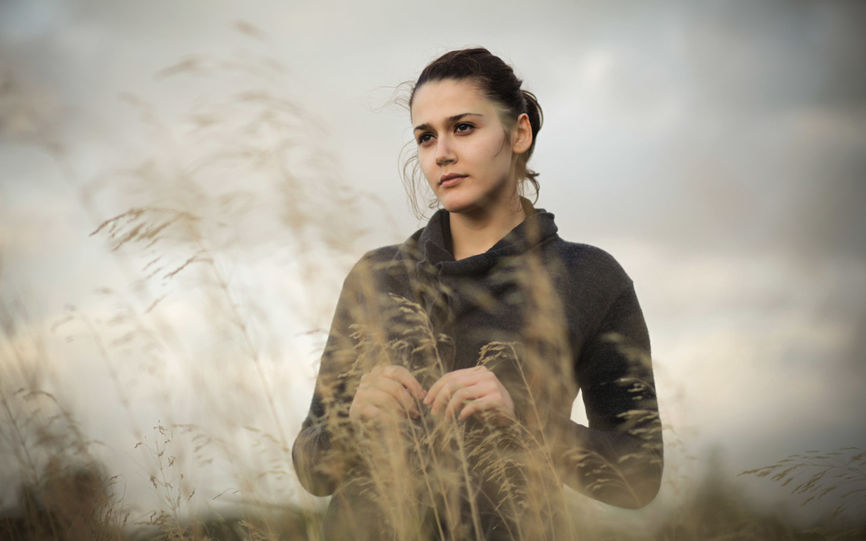 Bilde av en dame som står ute i en eng av siv.