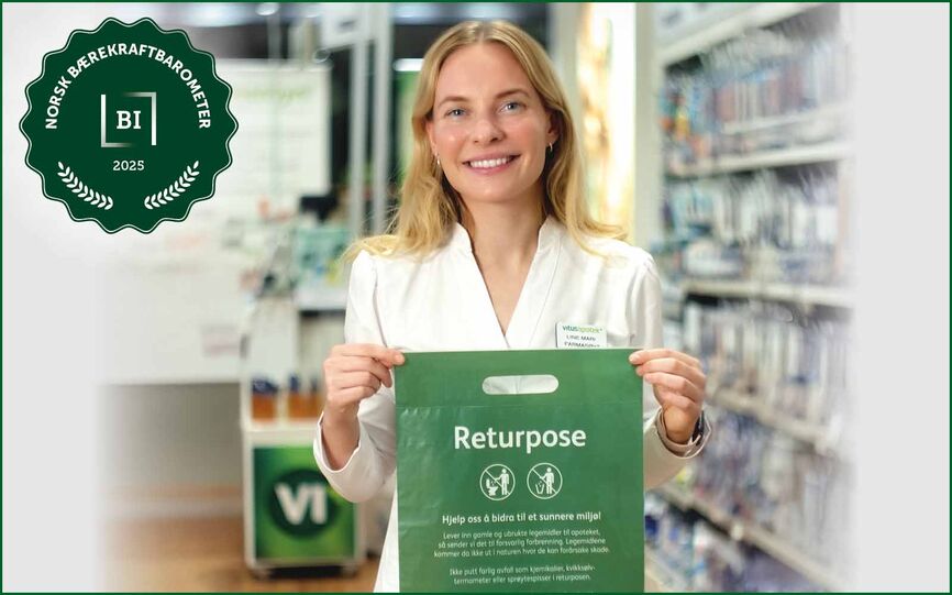 Ansatt i Vitusapotek viser frem grønn returpose for medisiner.