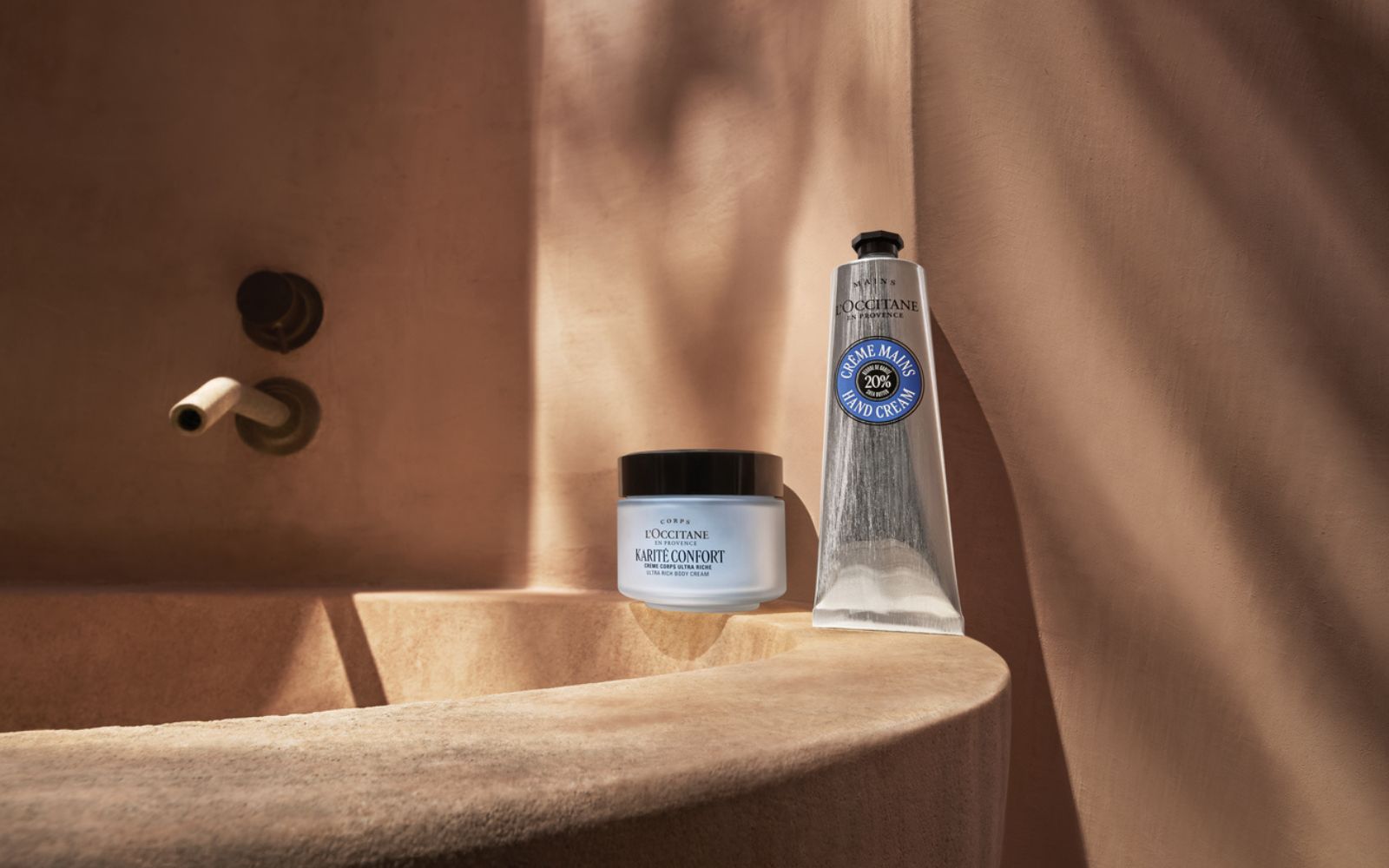 En tube og en krukke står stilt opp mot en terakottafarget vegg