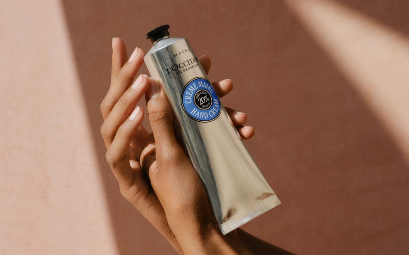 En kvinne holder en kremtube i hånden